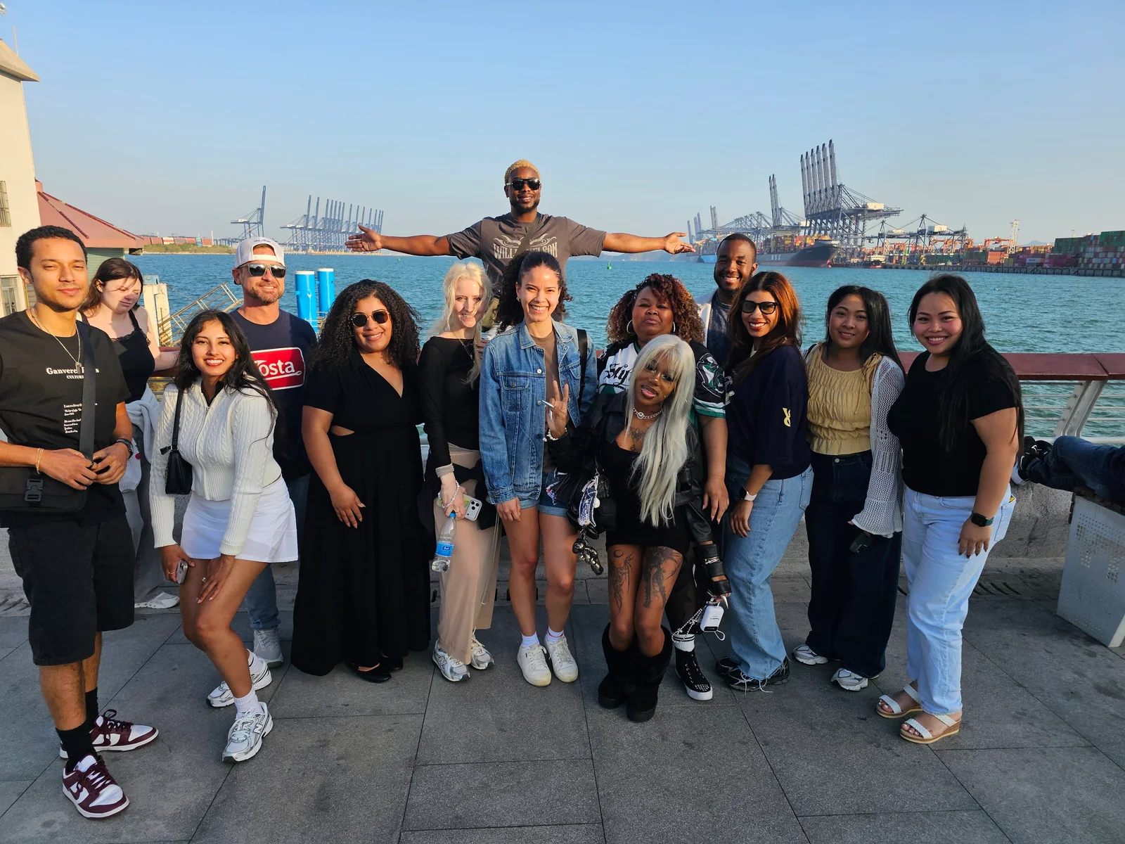The collective gathered beside the waterfront on a sunny day